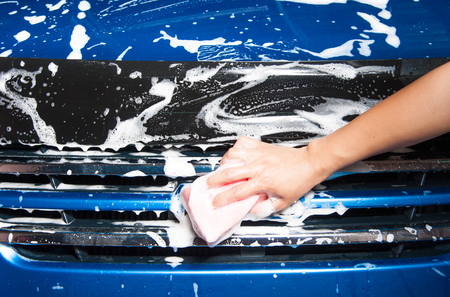 hand hold sponge over the car for washingの写真素材