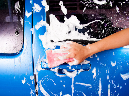 hand hold sponge over the car for washingの写真素材