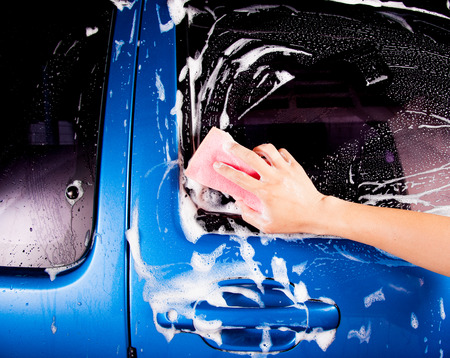 hand hold sponge over the car for washingの写真素材