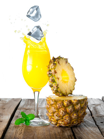 Pineapple and ice with splash on woodの写真素材