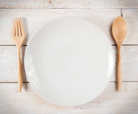plate with fork and spoon on white woodの写真素材
