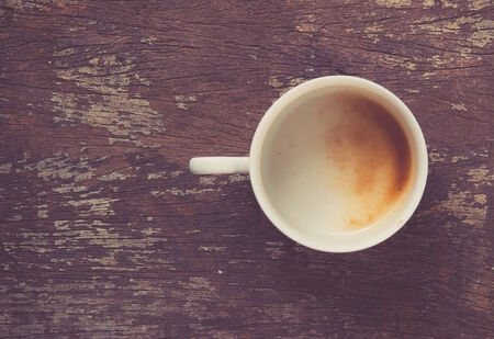 empty coffee cup on wood table, retro filter effectの写真素材