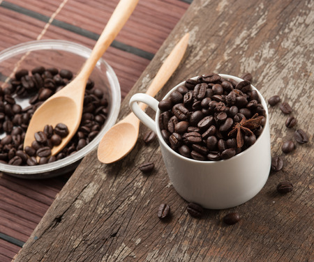 Coffee beans in cup on wood background,selective focusの写真素材