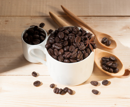 Coffee beans in cup on wood background,selective focusの写真素材