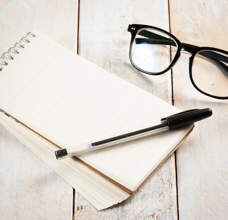 notepad,glasses and ink pen on the wooden