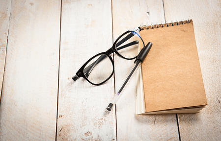 notepad,glasses and ink pen on the woodenの写真素材