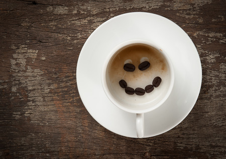 Empty cup of espresso coffee with smiling coffee beans on the table, Artistic selective focusの写真素材
