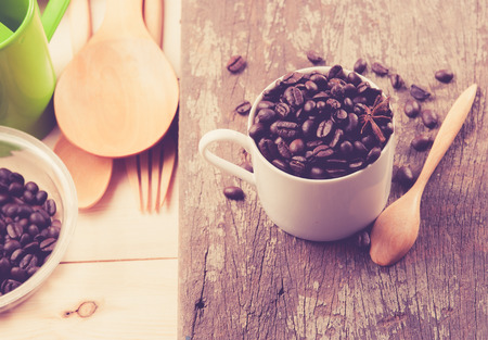 Coffee beans in cup on wood background,selective focus, retro filter effectの写真素材