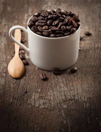 Coffee beans in cup on wood background,selective focusの写真素材