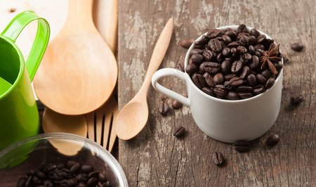 Coffee beans in cup on wood background,selective focusの写真素材