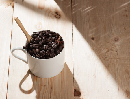Coffee beans in cup on wood background,selective focusの写真素材