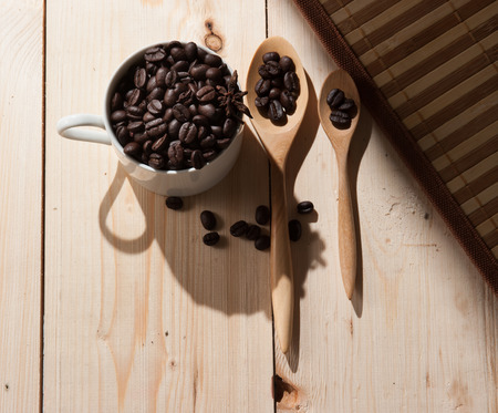 Coffee beans in cup on wood background,selective focusの写真素材