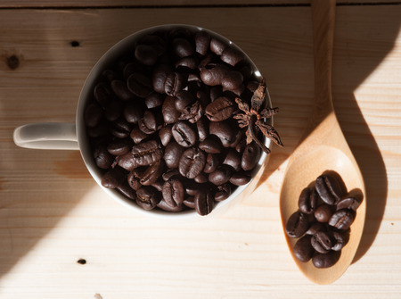Coffee beans in cup on wood background,selective focusの写真素材
