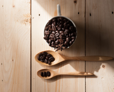 Coffee beans in cup on wood background,selective focusの写真素材