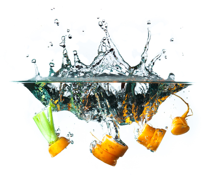 Carrot in the water splash over white background.の写真素材