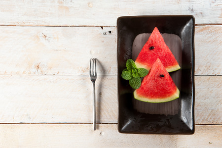 water-melon on a plate on wood backgroundの写真素材