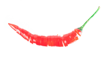 Sliced in pieces red chili pepper isolated over white backgroundの写真素材