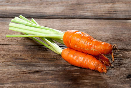 fresh carrots bunch on woodの写真素材