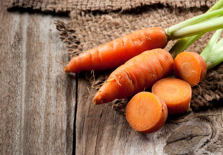 Fresh carrot with green leaves on jute bagの写真素材