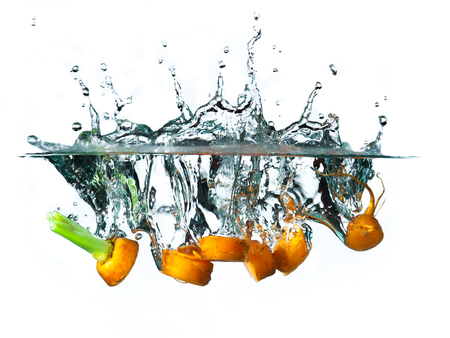 Carrot in the water splash over white background.の写真素材