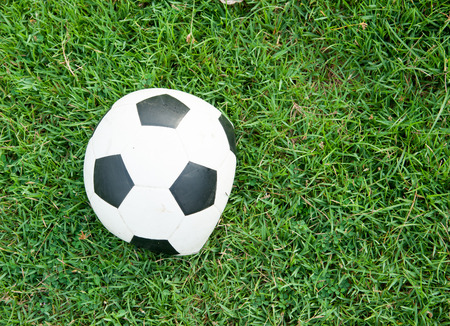 Deflated soccer ball on grassの写真素材