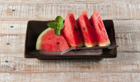 water-melon on a plate on wood backgroundの写真素材