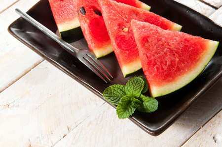 water-melon on a plate on wood backgroundの写真素材