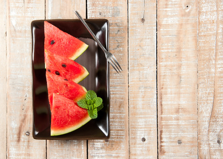 water-melon on a plate on wood backgroundの写真素材
