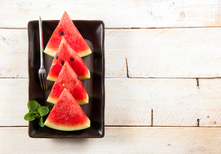 water-melon on a plate on wood backgroundの写真素材