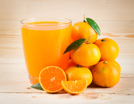 Orange juice and slices on woodの写真素材