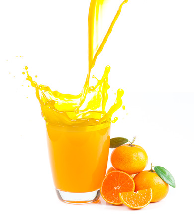 splashing orange juice with oranges against white の写真素材