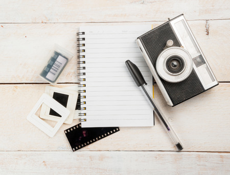 Old camera and film with diary on a woodenの写真素材