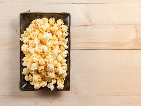 Popcorn in a bowl on wooden tableの写真素材