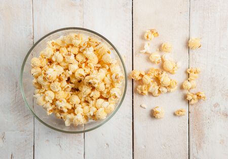 Popcorn in a bowl on wooden tableの写真素材
