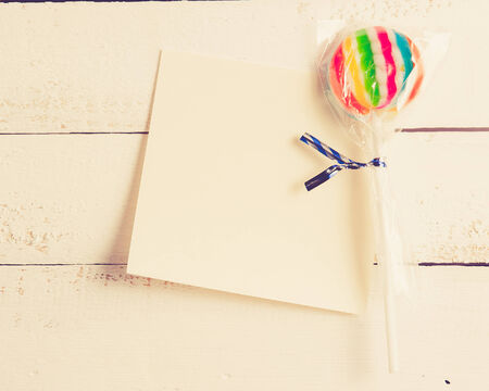 card with lollipops and on white wood,vintage color toned imageの写真素材