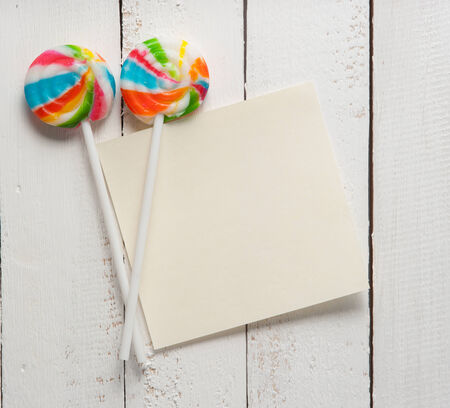 card with lollipops and on white woodの写真素材