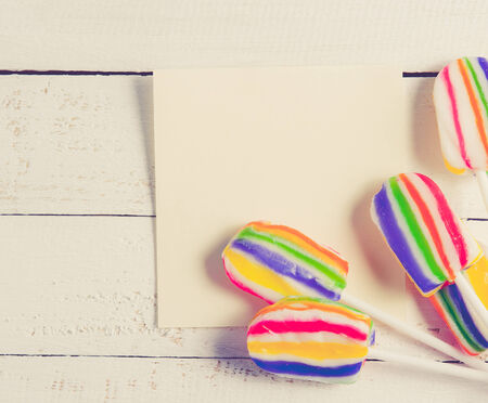 card with lollipops and on white wood,vintage color toned imageの写真素材
