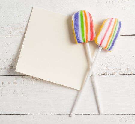 card with lollipops and on white woodの写真素材