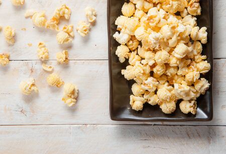 Popcorn in a bowl on wooden tableの写真素材