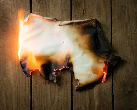 Fire paper on wooden backgroundの写真素材
