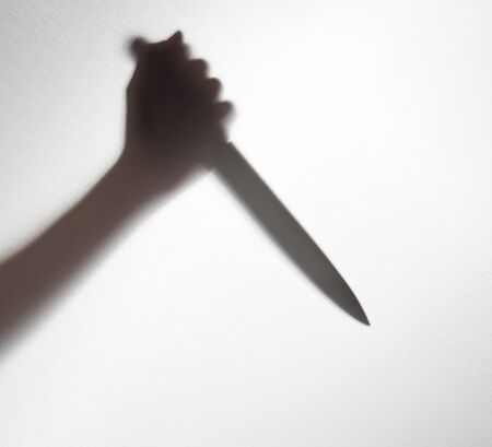 Silhouette of someone holding knife,blur imageの写真素材