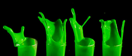 splashes of green paint isolated on black backgroundの写真素材