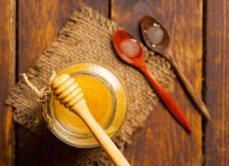 Honey drip in jar on the tableの写真素材
