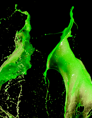 splashes of green paint isolated on black backgroundの写真素材