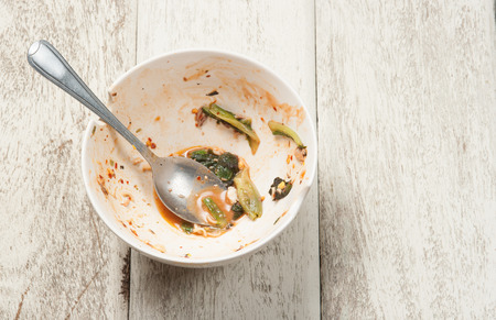 Empty dish after food on white woodの写真素材