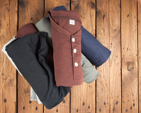 Rolled T Shirts on wood background