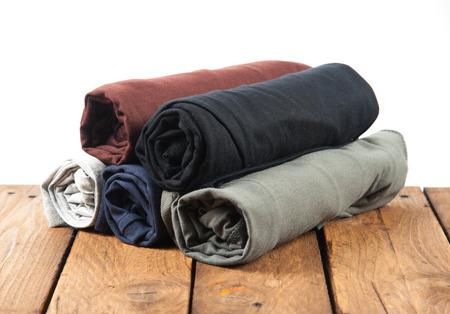 Rolled T Shirts on wood background