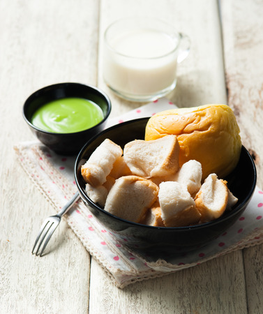 Thai dessert , Slice steamed bread and pandan custard on woodの写真素材