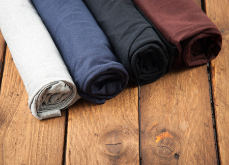 Rolled T Shirts on wood backgroundの写真素材