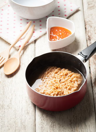 Instant noodles in frying pan on woodの写真素材